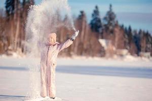 adorável menina feliz trenó em dia de inverno nevado. foto