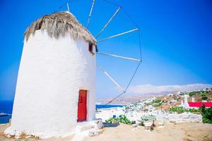 vista famosa dos moinhos de vento gregos tradicionais na ilha de mykonos ao nascer do sol, cyclades, grécia foto