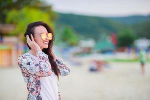 jovem mulher bonita na praia tropical de areia branca. garota caucasiana no pôr do sol foto