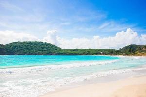 idílica praia tropical com areia branca, água azul-turquesa e céu azul na ilha caribenha foto