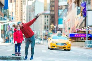 família de pai e filho na times square durante suas férias na cidade de nova york foto