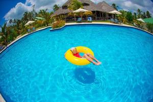 menina adorável feliz na piscina ao ar livre foto