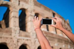 turista tirando uma foto pelo smartphone do grande coliseu, roma, itália