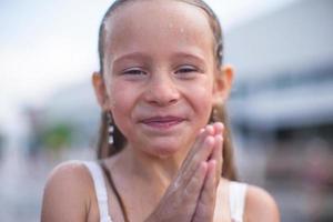 retrato de menina feliz na fonte ao ar livre foto