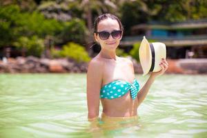 garota bonita feliz durante as férias na praia tropical foto