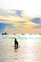 barco à vela e pessoas ao pôr do sol foto