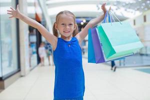 retrato de menina feliz segurando sacolas de compras no shopping foto