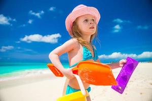 criança brincando com brinquedos de praia durante as férias tropicais foto