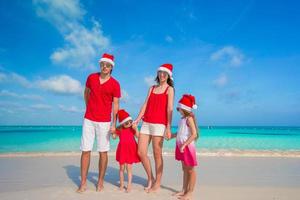 família feliz com dois filhos com chapéu de Papai Noel nas férias de verão foto