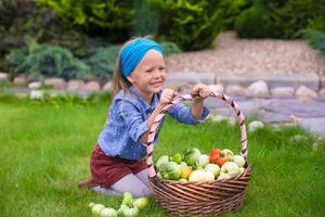 menina feliz com colheita de outono de tomate em cestas foto