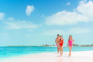 família linda feliz em umas férias de praia tropical foto