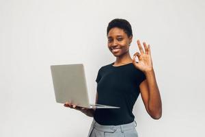 mulher negra segurando um laptop gesticulando foto