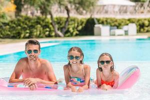 família feliz de três na piscina ao ar livre foto