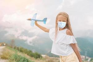 menina feliz com avião de brinquedo nas mãos nas montanhas foto