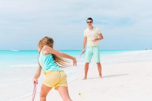 menina e pai feliz se divertindo durante as férias na praia foto