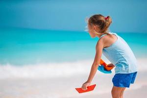 adorável menina se divertir na praia tropical durante as férias foto