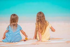 garotinhas felizes e engraçadas se divertem muito na praia tropical brincando juntas foto