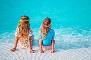 adoráveis meninas brincando na piscina ao ar livre de férias foto