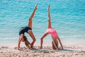 garotinhas engraçadas felizes se divertem muito na praia tropical brincando juntas. foto