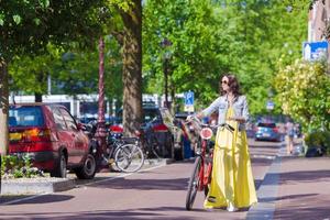 jovem mulher bonita em bicicleta na cidade europeia foto