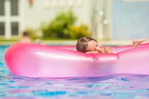 garota adorável feliz se divertindo na piscina ao ar livre foto