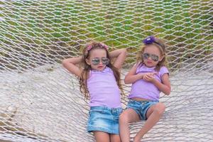 meninas doces relaxando na rede nas férias de verão foto