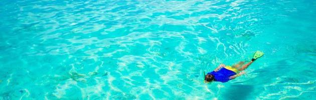jovem mergulhando em águas cristalinas tropicais azul-turquesa foto