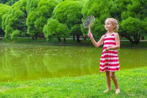 menina bonitinha jogando badminton no piquenique foto