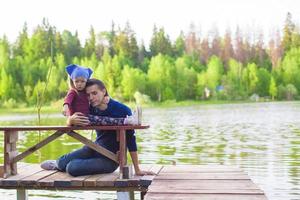 jovem pai e sua filha no cais à beira do lago foto