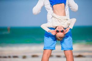 menina e pai feliz se divertindo durante as férias na praia foto