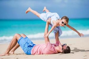 família de pai e menina esportiva se divertindo na praia foto