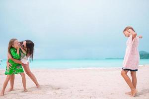 linda mãe e suas adoráveis filhas na praia foto