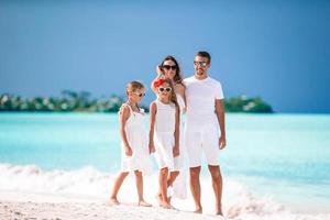 jovem família de quatro pessoas de férias divirta-se foto