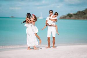 família linda feliz com crianças na praia foto