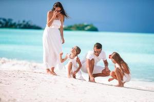 família linda feliz com crianças na praia foto