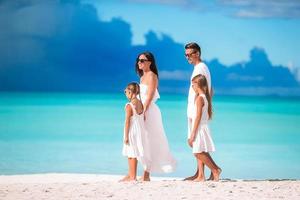 família linda feliz com crianças na praia foto