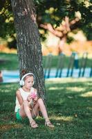 menina adorável ouvindo música no parque foto