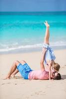 família de pai e menina esportiva se divertindo na praia foto