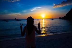 silhueta de menina ao pôr do sol colorido na ilha boracay, filipinas foto