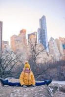 menina adorável com vista para a pista de gelo no central park em manhattan na cidade de nova york foto