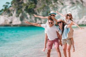 família linda feliz com crianças na praia foto