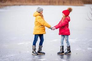 adoráveis meninas patinando na pista de gelo foto