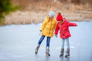 adoráveis meninas patinando na pista de gelo foto