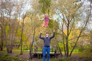 jovem pai com sua filha bonitinha se divertir ao ar livre no parque foto