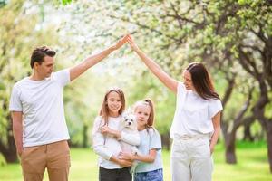 família adorável no jardim cerejeira florescendo em lindo dia de primavera foto