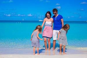 família de quatro pessoas com dois filhos durante as férias na praia foto