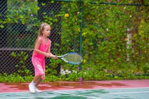 menina jogando tênis na quadra foto