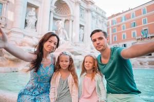 família feliz perto de fontana di trevi com mapa da cidade foto