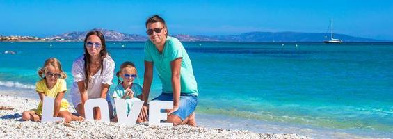 família feliz de quatro pessoas durante as férias de verão na praia foto