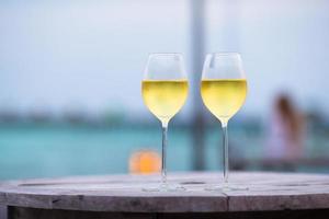 dois copos de vinho branco saboroso ao pôr do sol foto